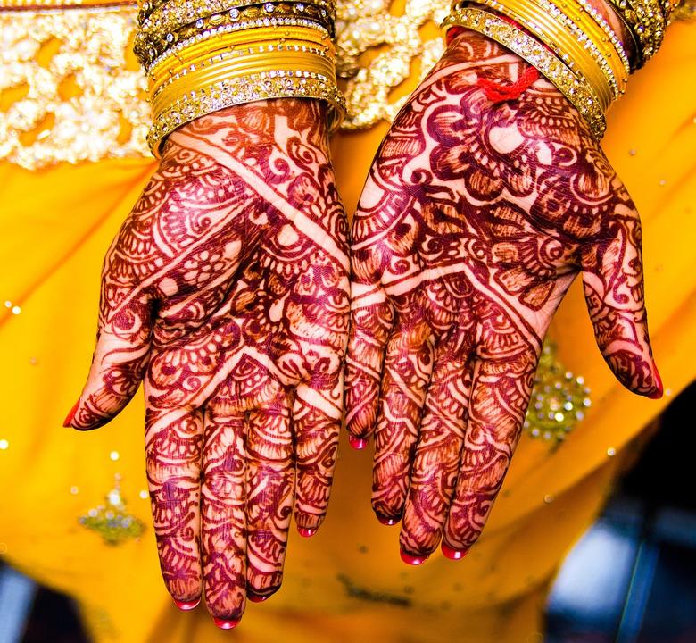 Mehndi on the bride's palms, with gold bangles